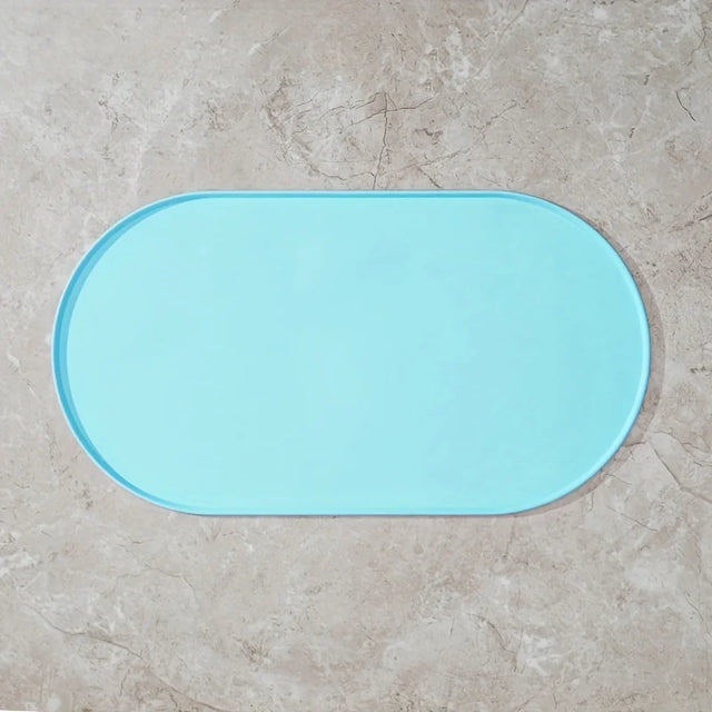 Light blue bath mat on a beige tiled floor