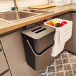 Kitchen compost bin with food waste next to a sink