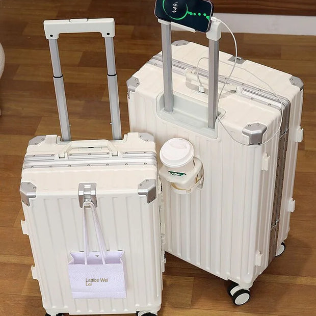 Two white suitcases on a wooden floor with a smartphone on top.