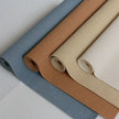 Four rolls of fabric in gray, brown, beige, and white on a light gray background