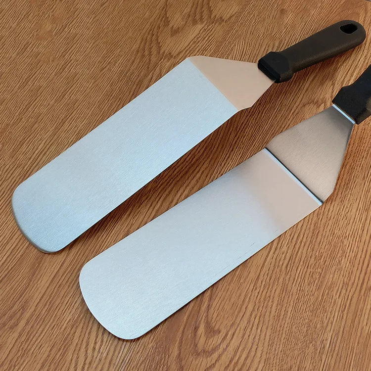 Two spatulas with light blue silicone heads on a wooden surface