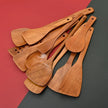 Set of wooden cooking utensils on a two-tone red and gray background