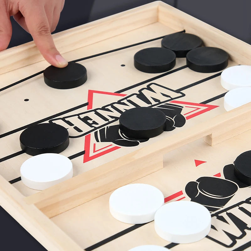 Hand playing a game of checkers on a wooden board with black and white pieces.