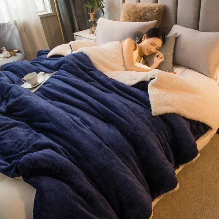 Woman lying on a bed under a blue blanket with a cup and saucer on a tray.