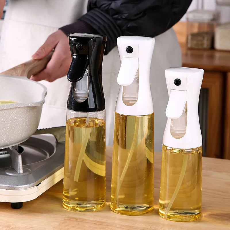 Three glass bottles with spray nozzles filled with a yellow liquid on a wooden surface.