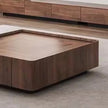 Wooden coffee table with a minimalist design on a concrete floor.