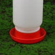 White plastic bottle with a red base on a green grass background