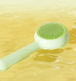 Green pet grooming brush on a yellow background