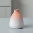 Ceramic vase with gradient color from pink to white on a neutral background