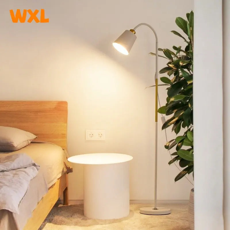 Modern bedroom setup with a bed, side table, and floor lamp, featuring the brand 'WXL'.