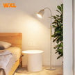 Modern bedroom setup with a bed, side table, and floor lamp, featuring the brand 'WXL'.