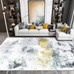 Modern living room with a gray sofa, decorative pillows, and an abstract patterned rug.