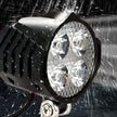 Water-resistant outdoor light fixture with raindrops on a dark background