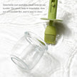 Green brush next to a clear glass jar on a white background with text about the brush's features.