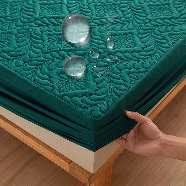 Teal mattress cover with water droplets on a wooden bed frame