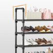 Black metal shoe rack with shoes on a white background