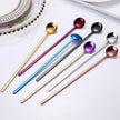 Set of colorful spoons on a white surface