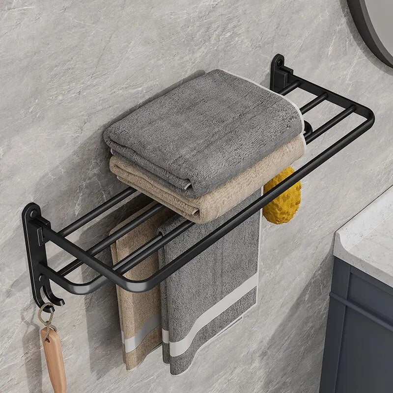 Black metal towel rack with folded towels on a bathroom wall.