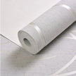 Roll of textured white wallpaper on a light gray surface