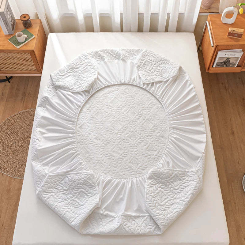 White mattress cover on a bed in a bedroom setting