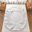 White mattress cover on a bed in a bedroom setting