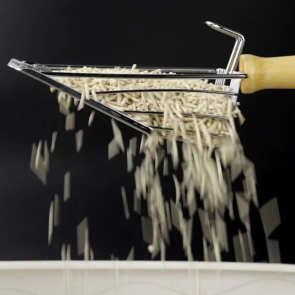 Pasta shaper with fresh pasta strands against a black background
