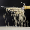 Pasta shaper with fresh pasta strands against a black background