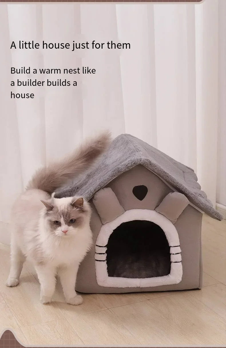 Cat standing next to a small house-like pet bed with text on a light background