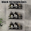 Three black rectangular wall shelves with various bottles and items on a gray tiled wall.