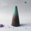 Tapered ceramic vase with gradient finish on a light gray background