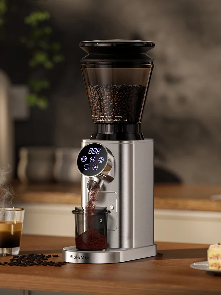 Coffee grinder with digital display on a wooden surface, surrounded by coffee beans and a glass of coffee.