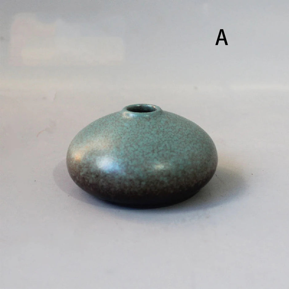 Small ceramic vase with a textured surface on a plain background