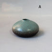 Small ceramic vase with a textured surface on a plain background