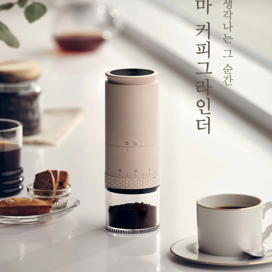 Coffee grinder with coffee cup and beans on a table