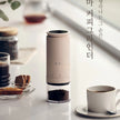 Coffee grinder with coffee cup and beans on a table