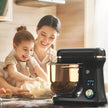 Woman and child in a kitchen with a stand mixer