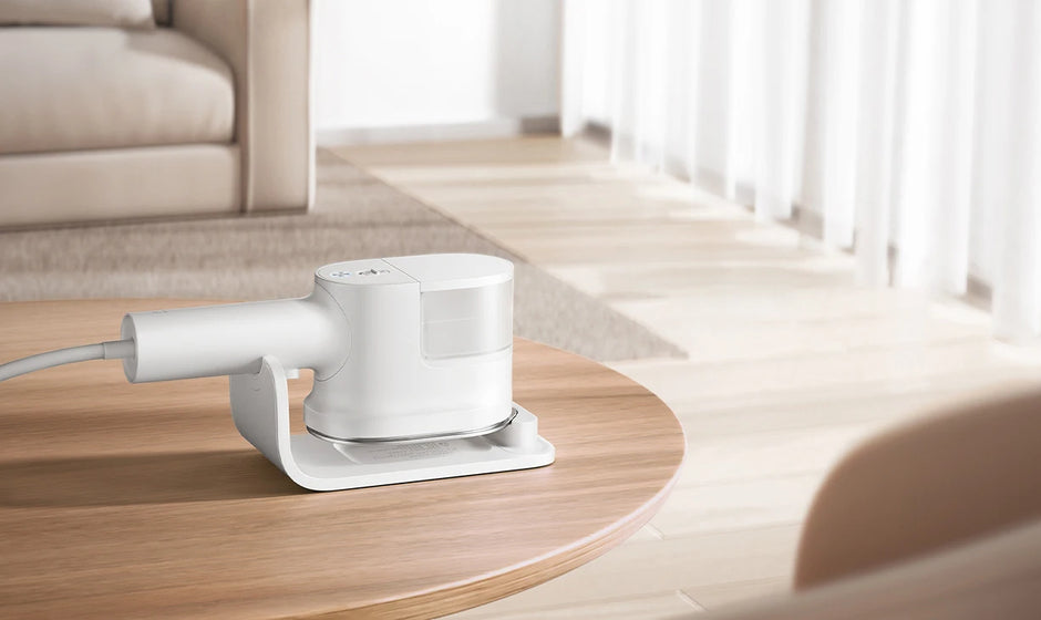 White electronic device on a wooden table in a bright room with light-colored furniture.