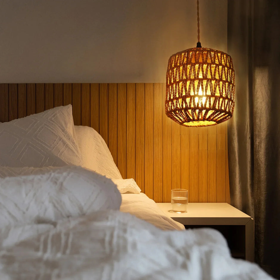 Bedroom with wooden headboard, white bedding, and a hanging lamp.