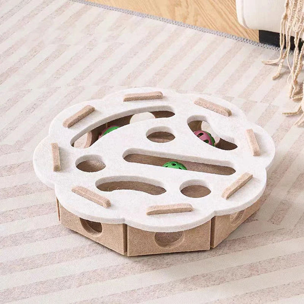 Cat toy with cardboard base and white top on a striped carpet