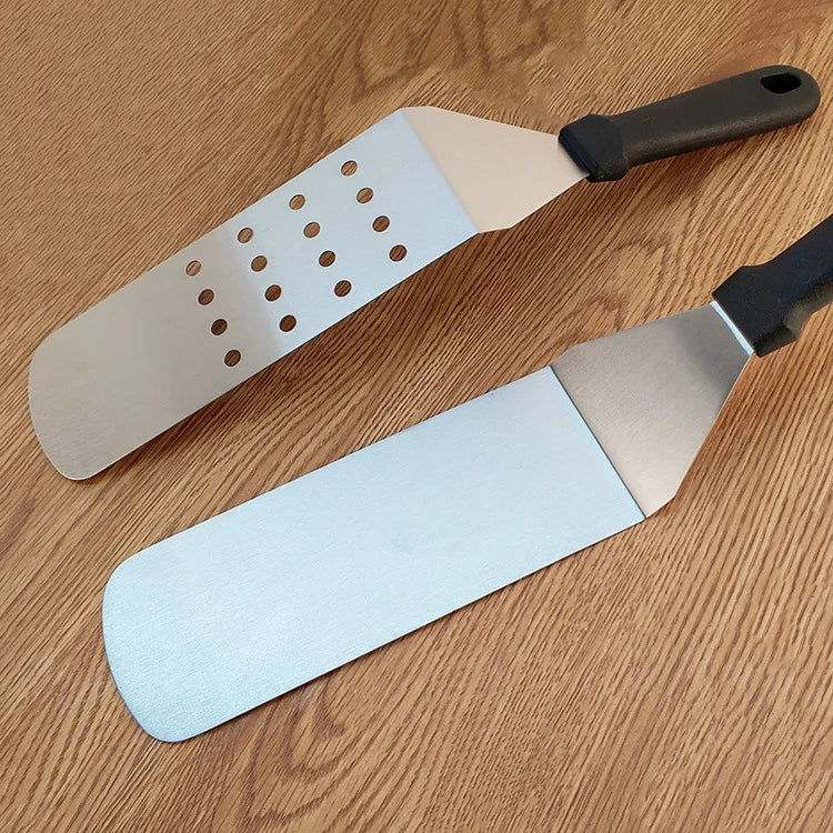 Two spatulas with different designs on a wooden surface