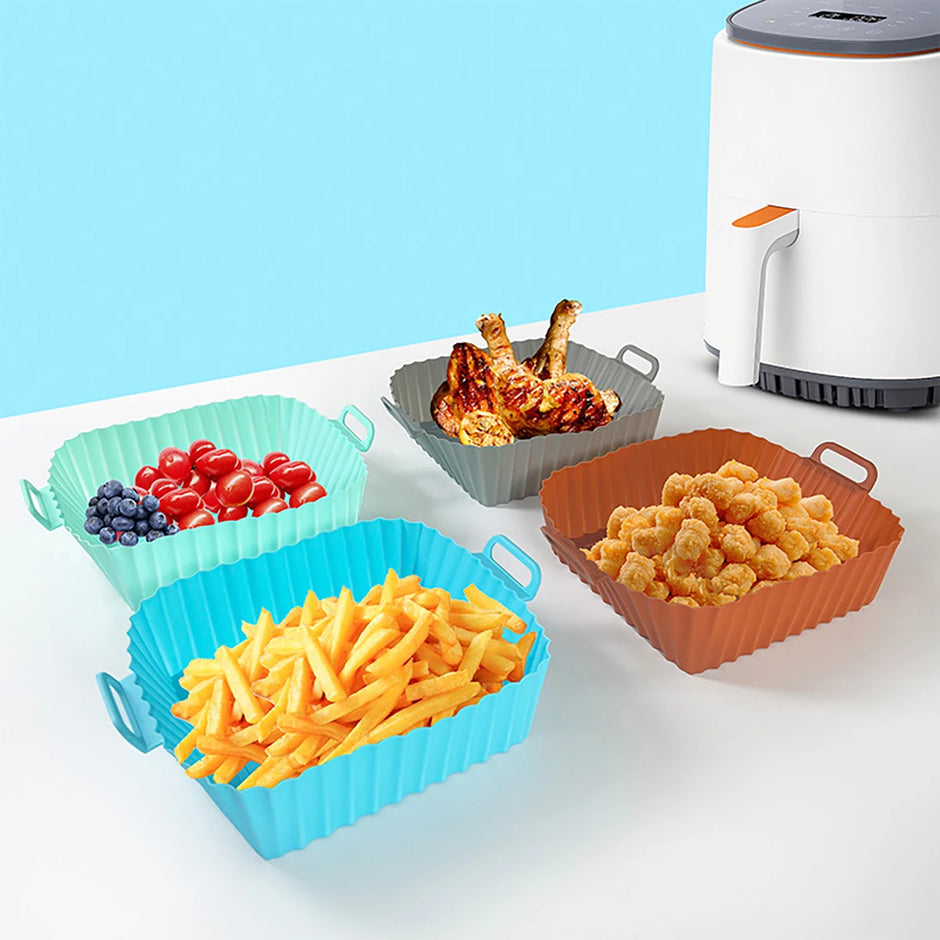 Colorful silicone basket set with various foods on a white surface against a blue background