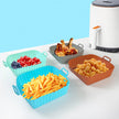 Colorful silicone basket set with various foods on a white surface against a blue background
