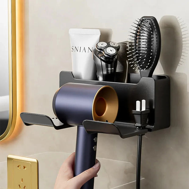 Wall-mounted hair dryer holder with various grooming tools on a bathroom wall.