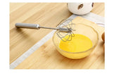 Glass bowl with whisked eggs on a wooden surface