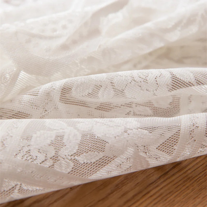 Close-up of beige lace fabric on a wooden surface