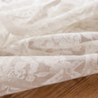 Close-up of beige lace fabric on a wooden surface