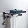 Black towel rack with folded towels and a brush on a tiled bathroom wall.