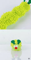 Green fuzzy caterpillar toy with a face on a white background