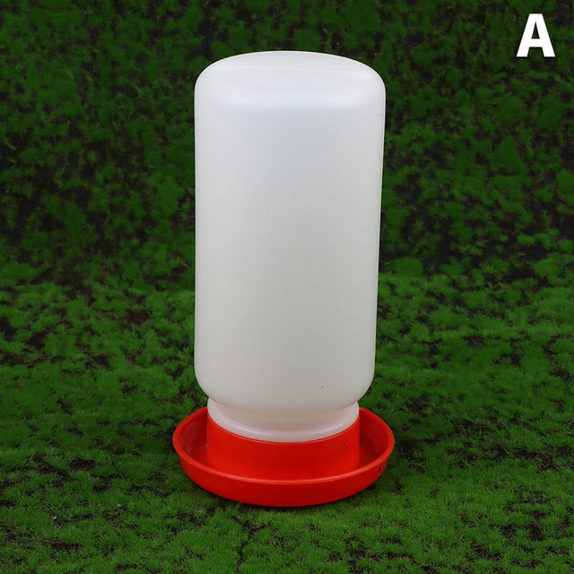 White plastic feeder with red base on a green grass background