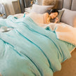 Person sleeping under a light blue comforter in a bedroom setting.